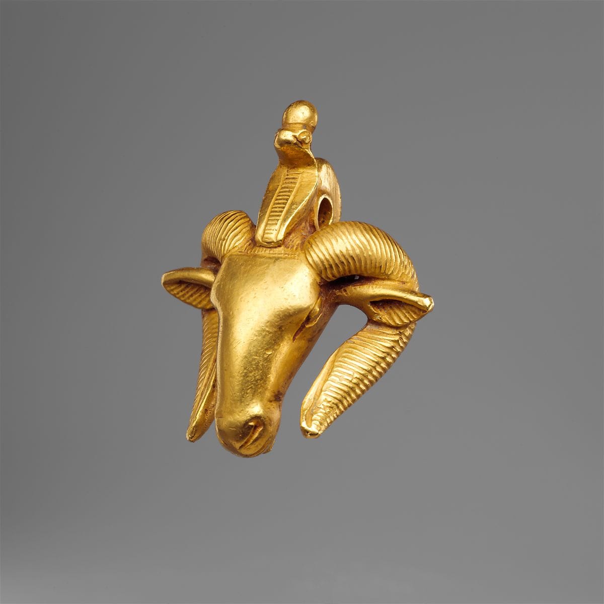 An ancient Egyptian gold ram's-head amulet