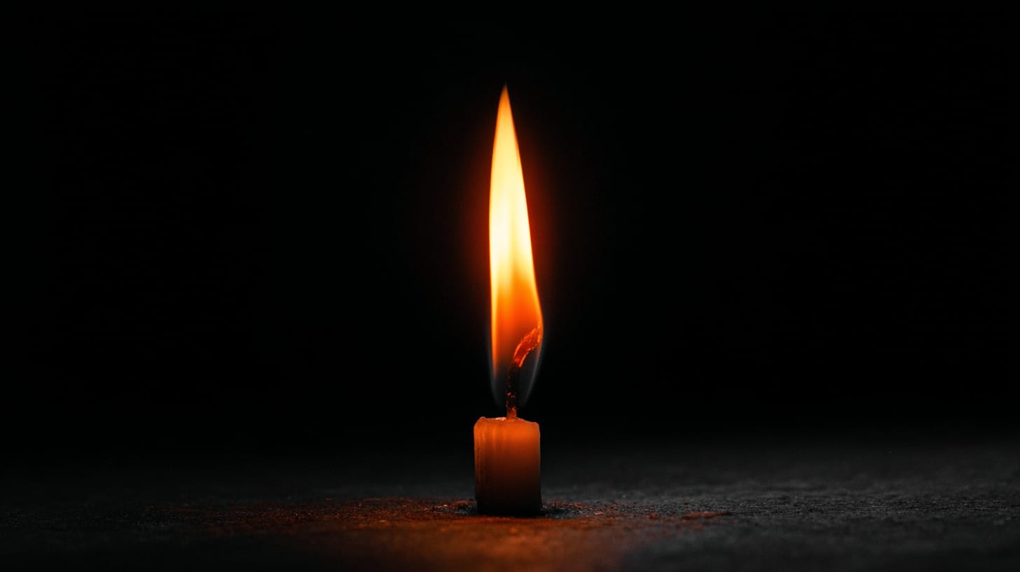 A single small flame burning in darkness